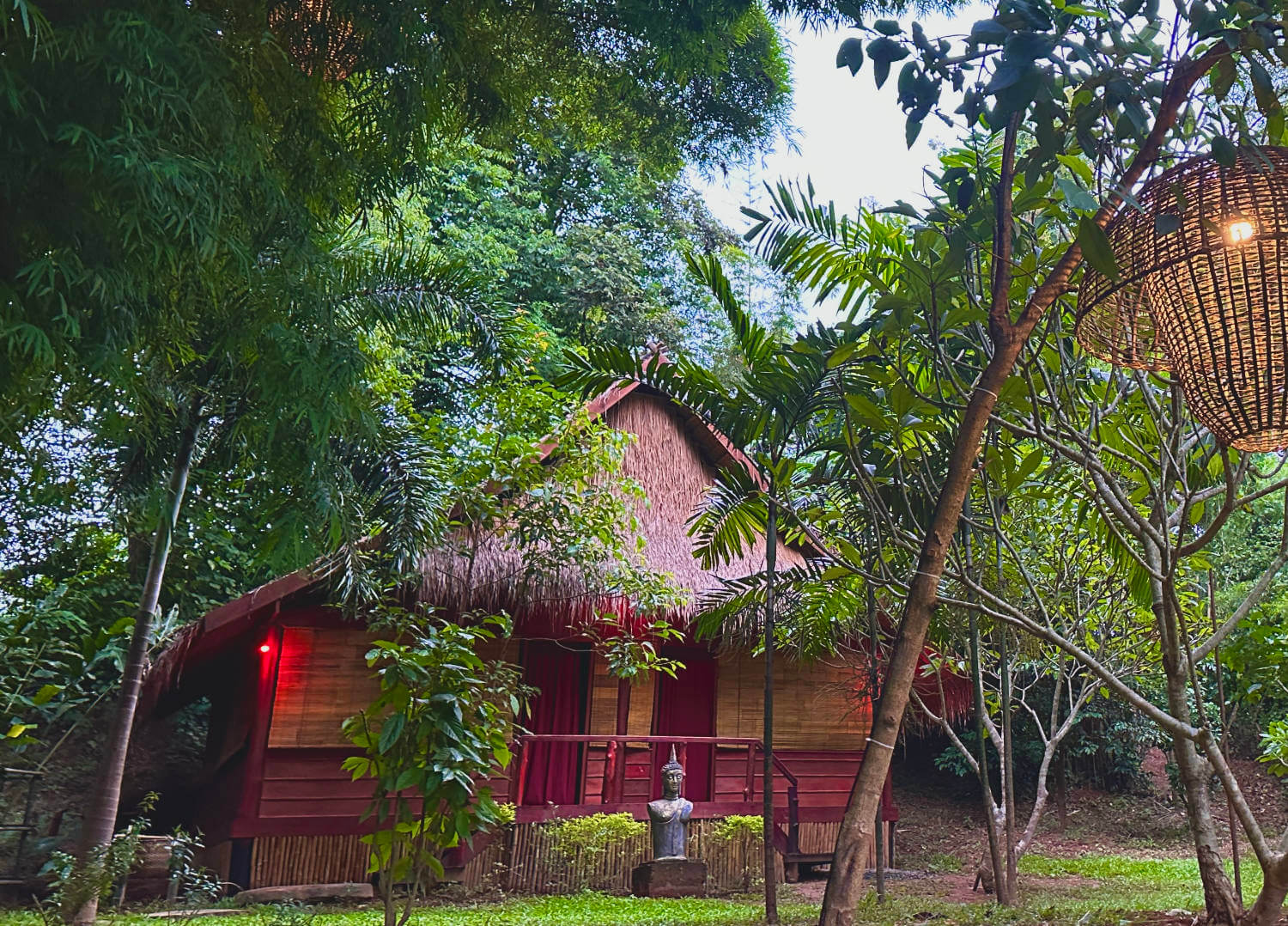 A rustic wooden house nestled in the lush forest of Luang Prabang.
