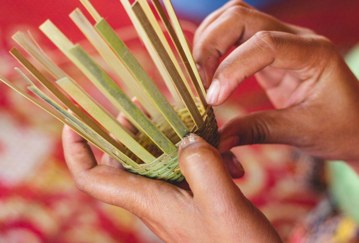A person is engaging in bamboo weaving to create a basket.