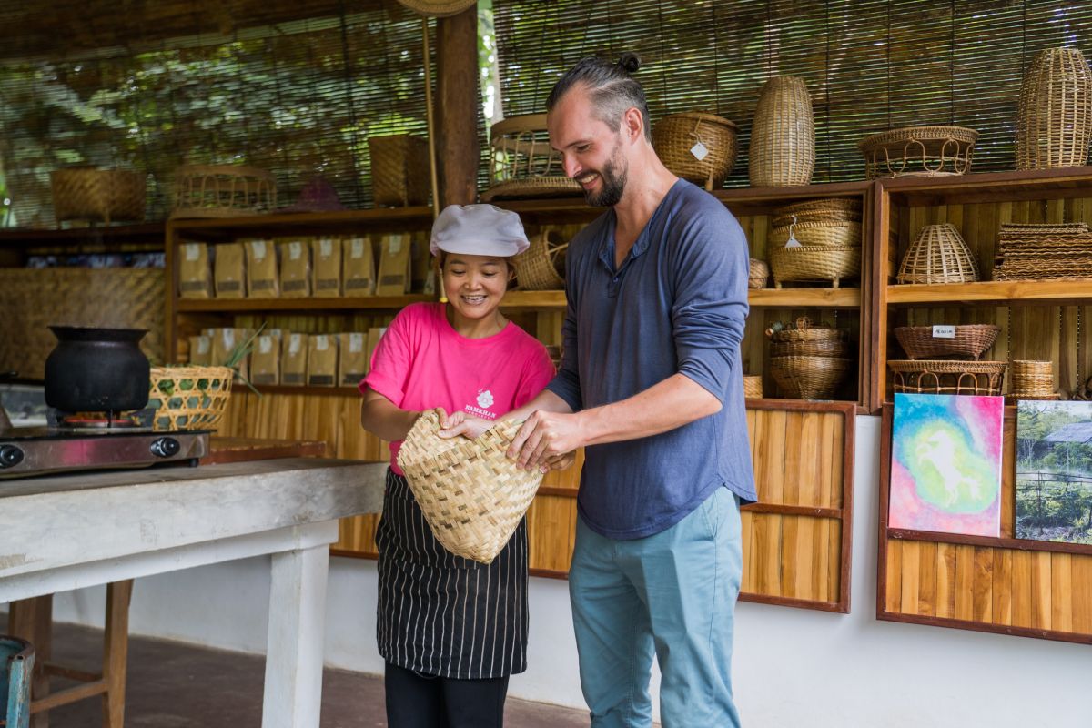 A man and a woman attending a cooking class, standing in front of a bamboo basket.