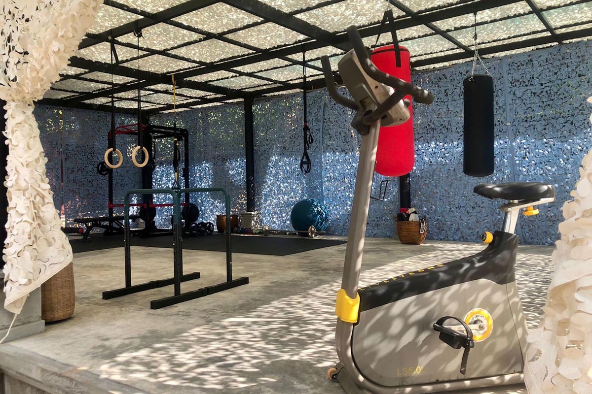 A fitness center with an exercise bike and a boxing ring.