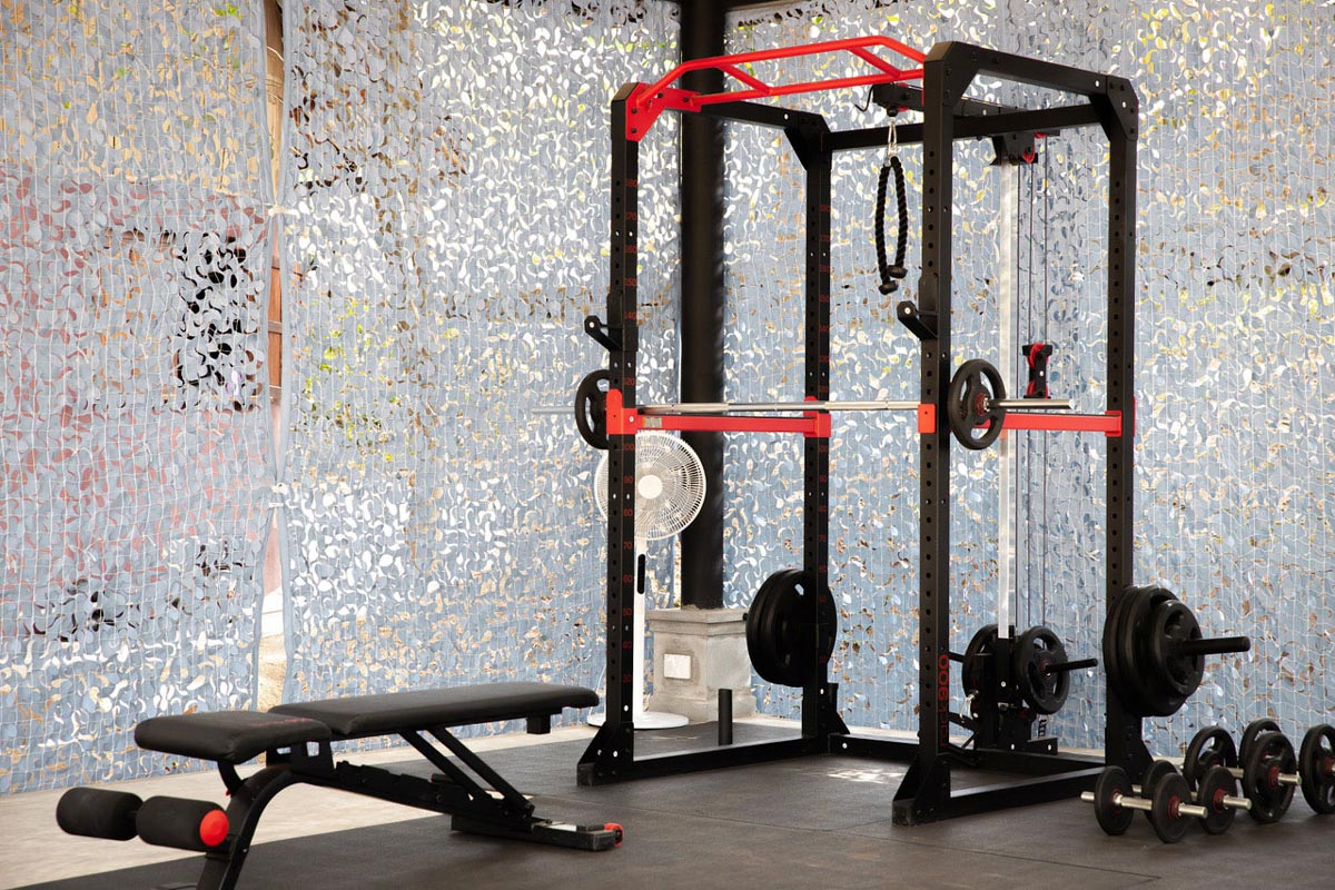 A fitness room with a squat rack and weights.