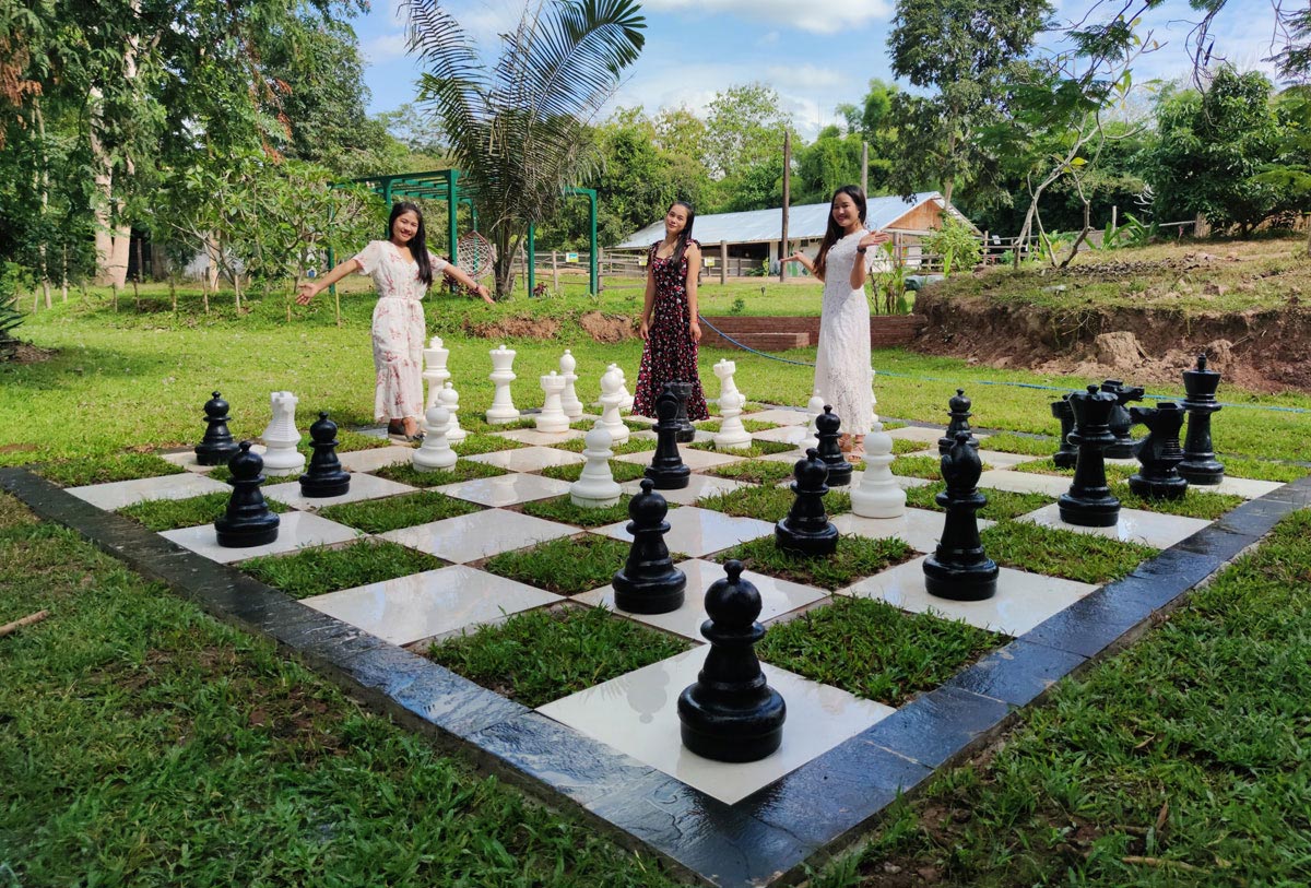 Two women standing on a chess board in an outdoor cinema.
