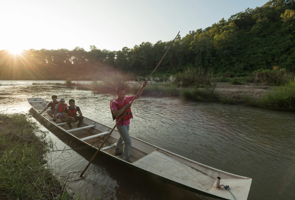 A group of people in a canoe exploring the Nam Khan river.