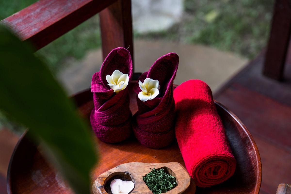A pair of red shoes and a towel on a wooden table promoting wellbeing.