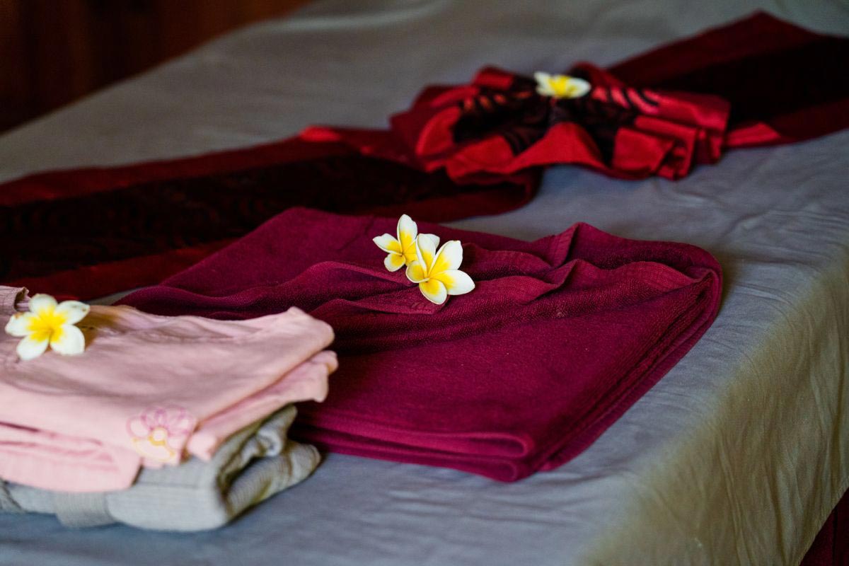 A bed adorned with refreshing flowers and plush towels, promoting a sense of wellbeing.