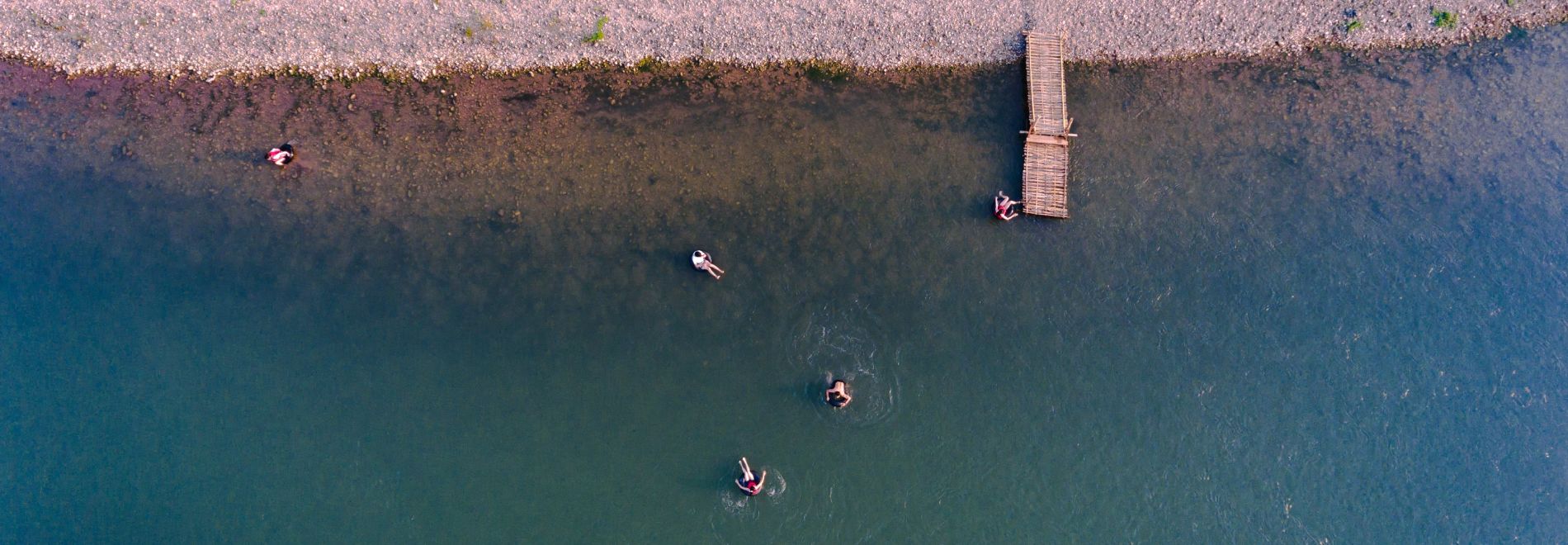 An aerial view of a group of people in the water enjoying their vacation packages.