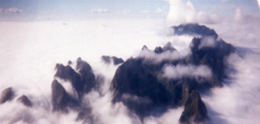 An aerial view of Phonsavan, Laos, with a mountain covered in clouds.