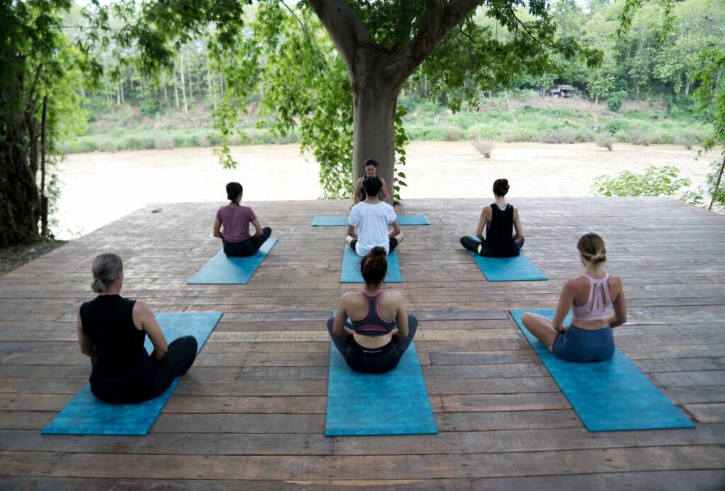 Yoga practitioners gathered on a serene wooden deck for their mindful practice.