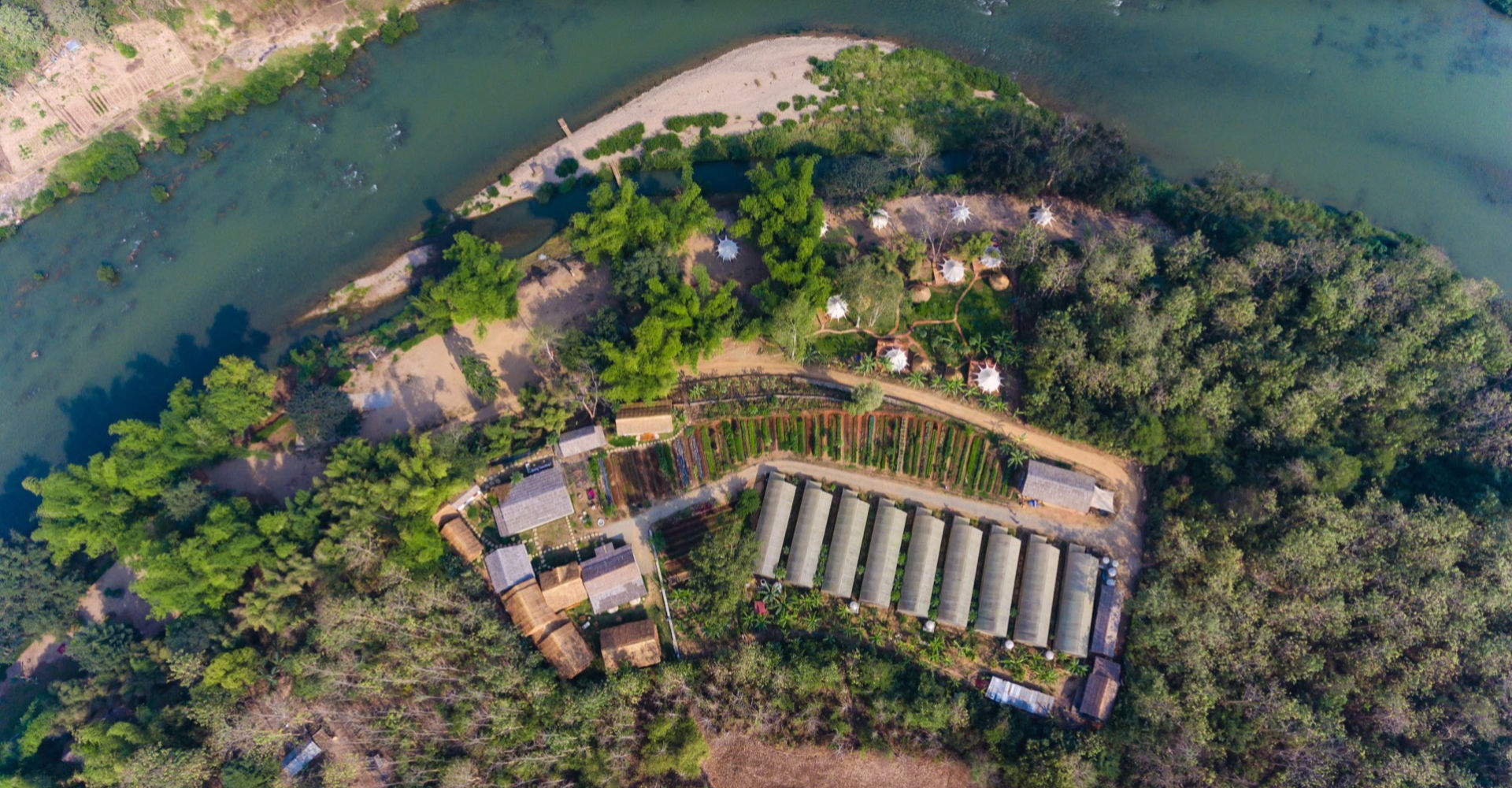 An aerial view of a luang prabang farm near a river.