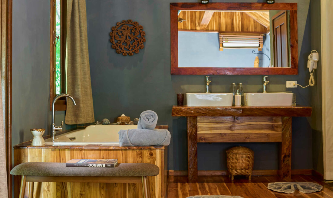 A bathroom in Luang Prabang featuring a wooden floor and a wooden sink.