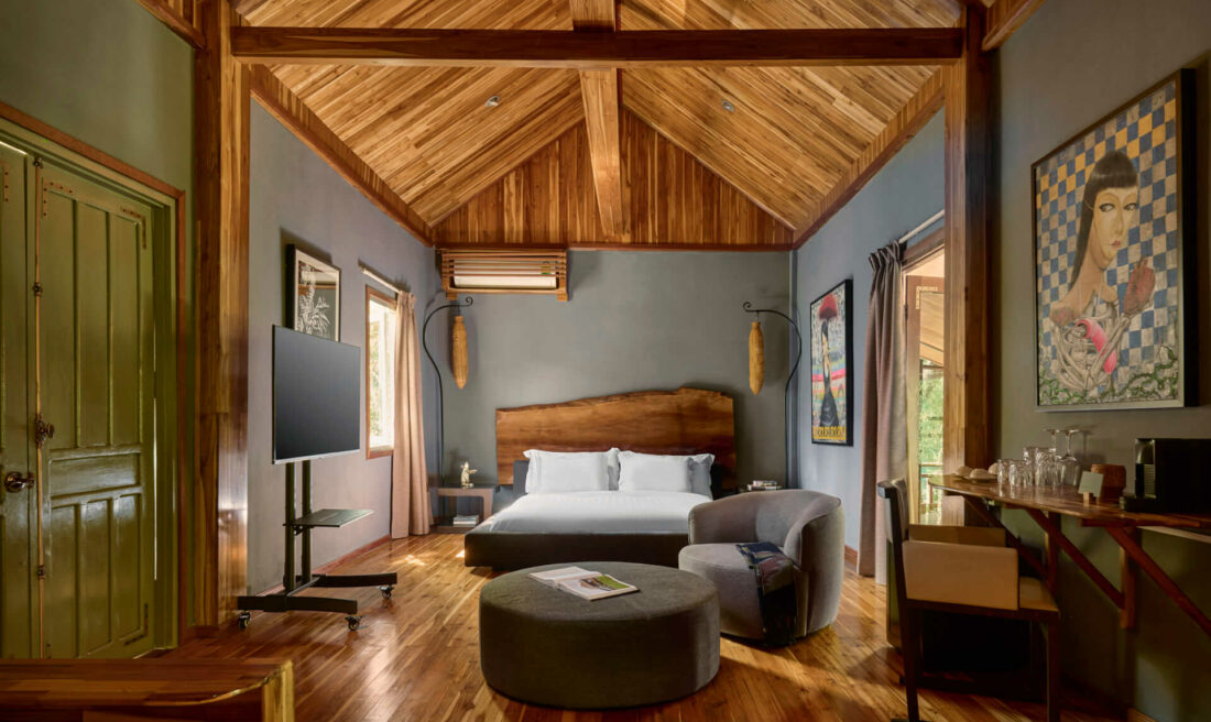 A bedroom with luang prabang wooden ceilings and wooden floors.
