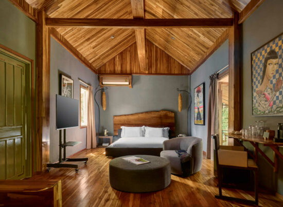 A bedroom with luang prabang wooden ceilings and wooden floors.