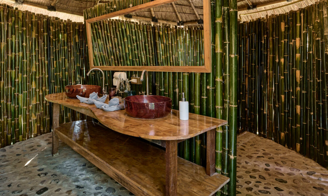 A luang prabang bathroom with bamboo walls and a sink.