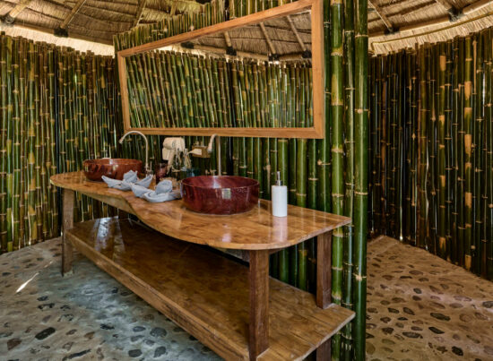 A luang prabang bathroom with bamboo walls and a sink.