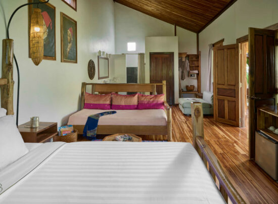 A luang prabang room with wooden floors and a bed.