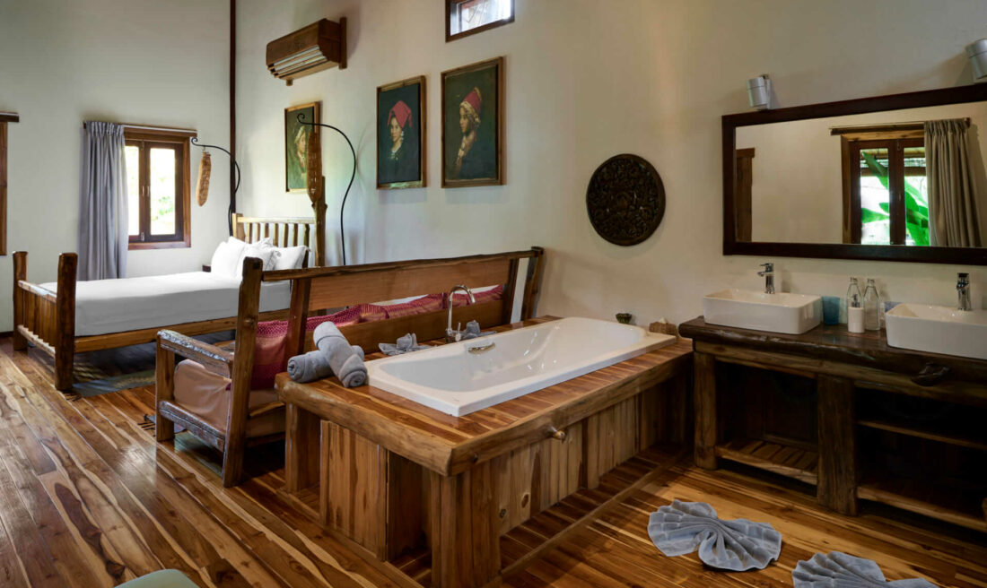 A bathroom in Luang Prabang with wooden floors and a bathtub.