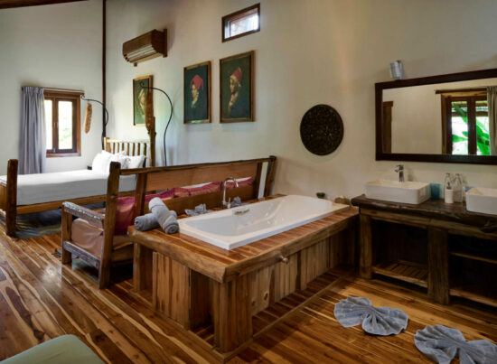 A bathroom in Luang Prabang with wooden floors and a bathtub.