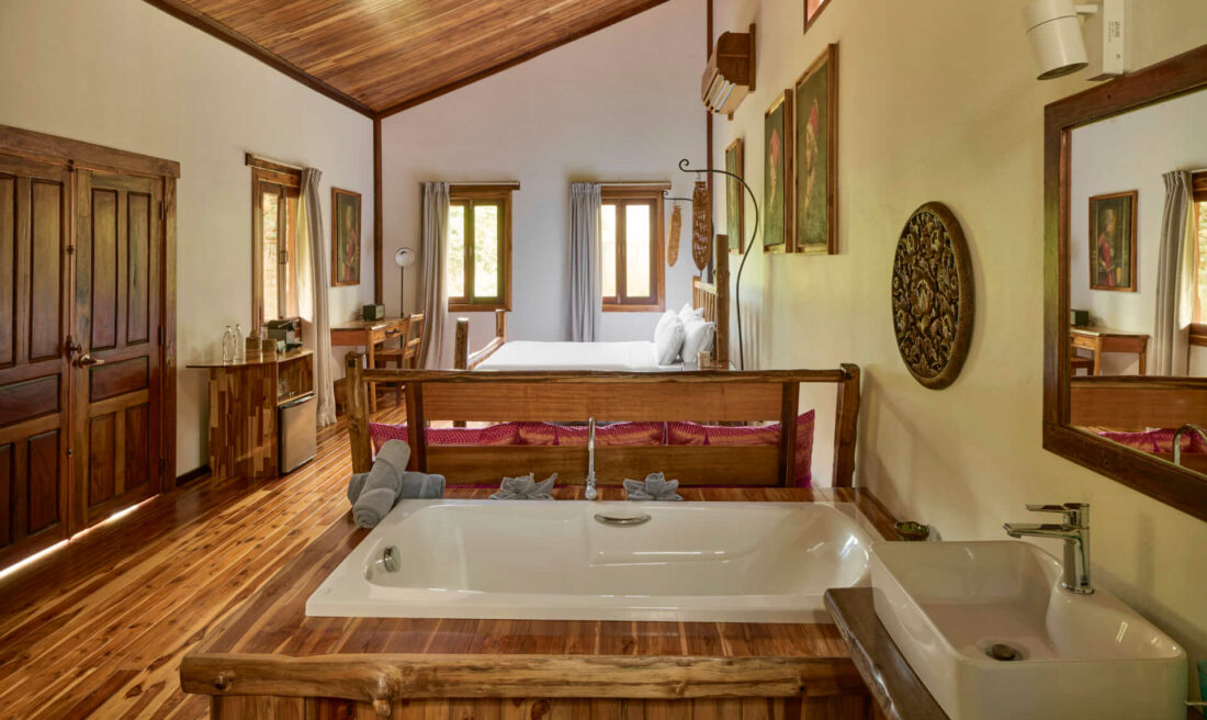 A bathroom in Luang Prabang with a wooden floor and a bathtub.