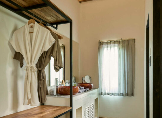 A room in Luang Prabang with a wooden floor and a wooden closet.