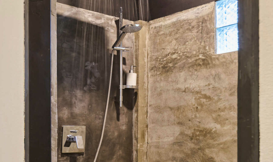 A luang prabang shower with a tiled floor and a luang prabang shower head.