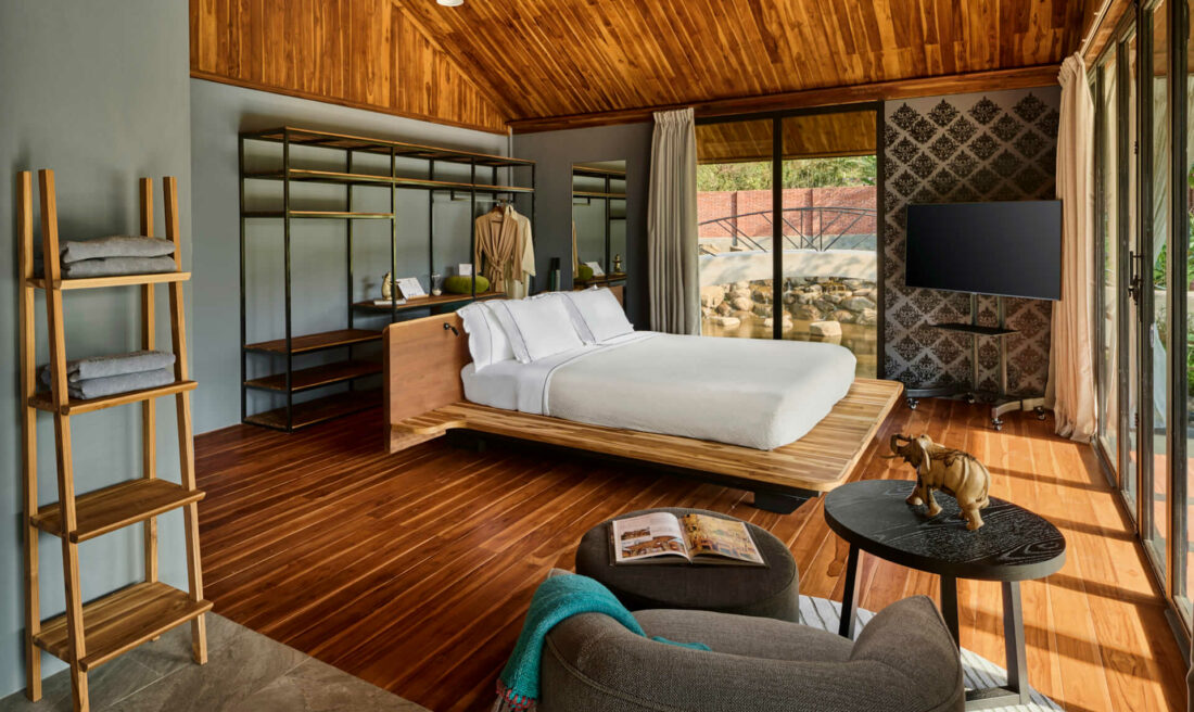 A luang prabang-style bedroom with wooden ceilings and wooden floors.