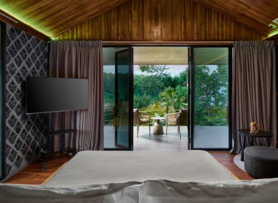 A luang prabang bedroom with sliding glass doors.
