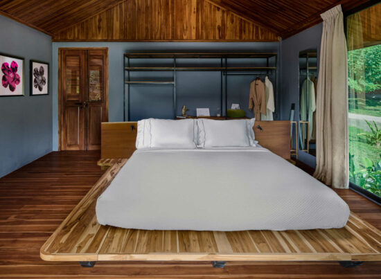 A luang prabang bed in a room adorned with wooden walls and wooden floors.
