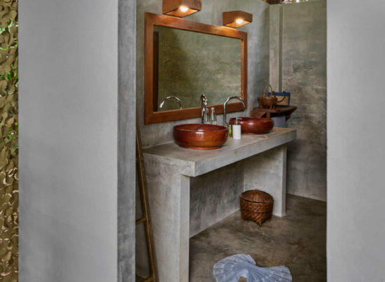 A luang prabang bathroom with two sinks and a wooden wall.