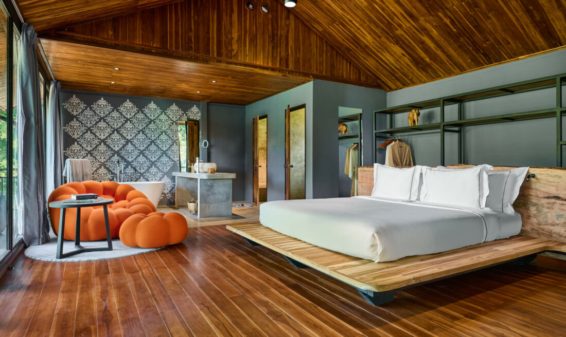 A bedroom in Luang Prabang with wooden floors and a bed.