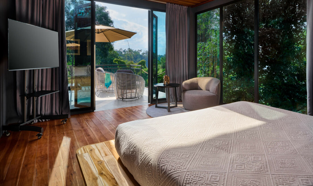 A bedroom in Luang Prabang with a large bed and sliding glass doors.