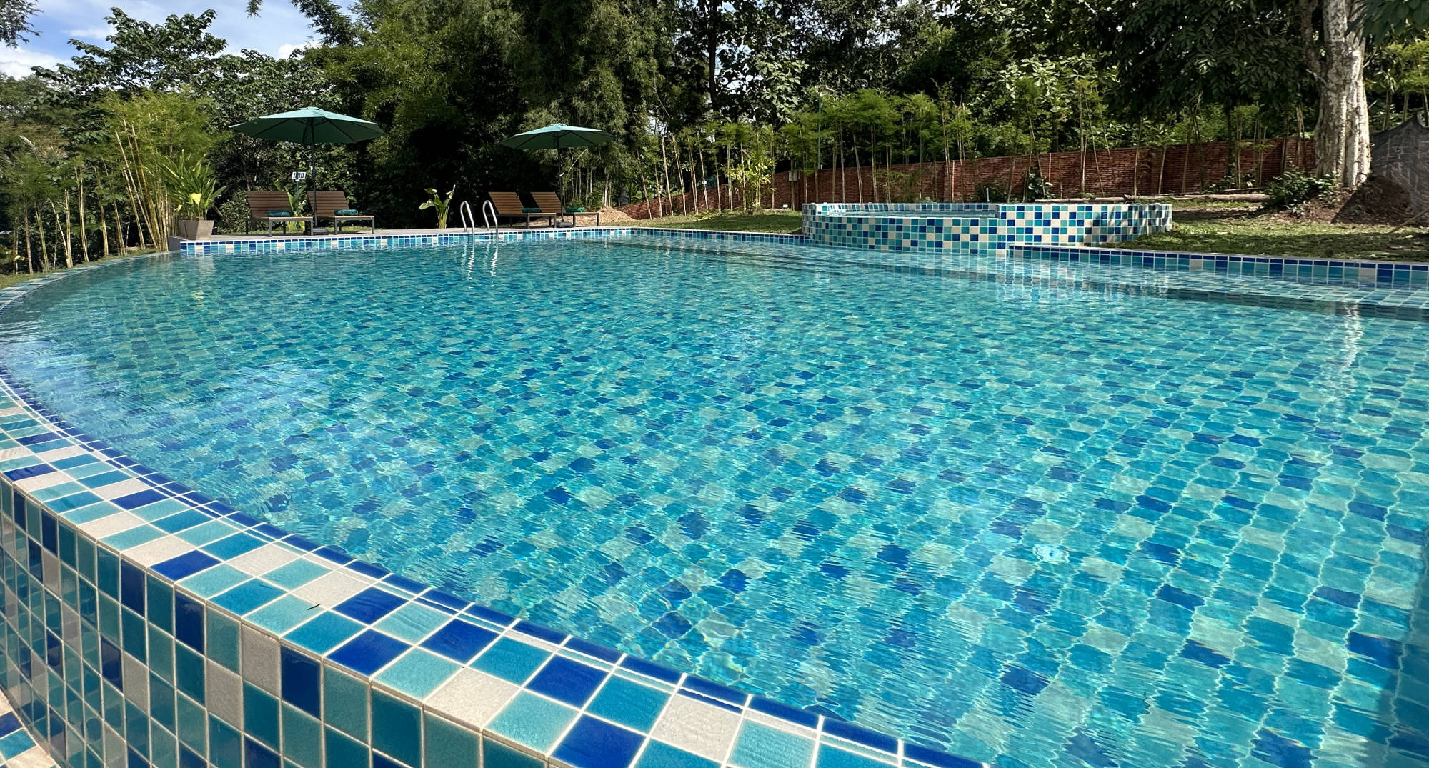 A Luang Prabang swimming pool with a blue tiled border.