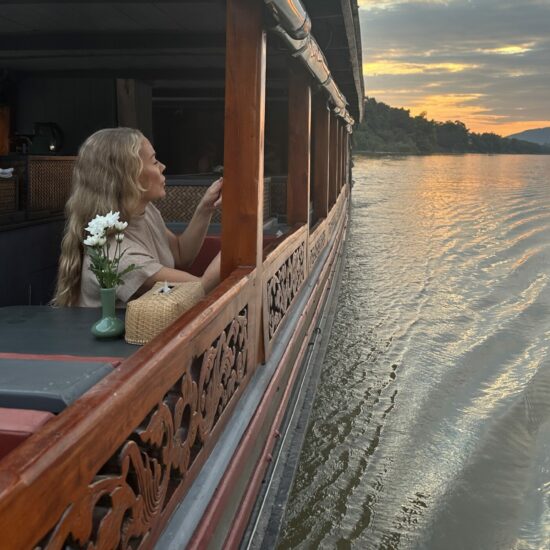 A woman is sitting on a boat in Luang Prabang.