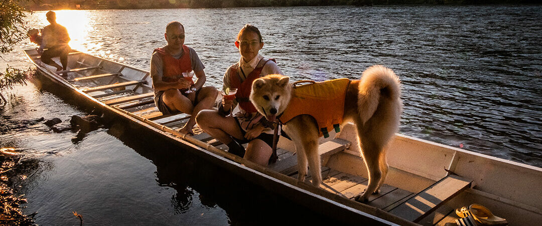 A group of people in a canoe with a dog exploring Luang Prabang.