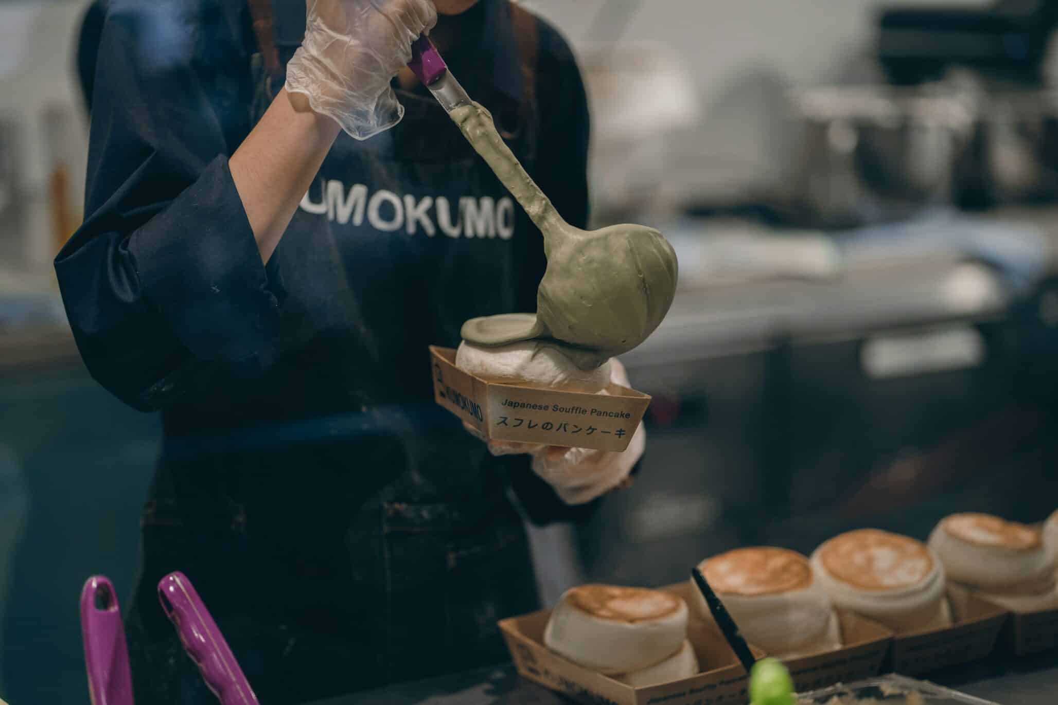 a woman in a kitchen preparing food with a spoon